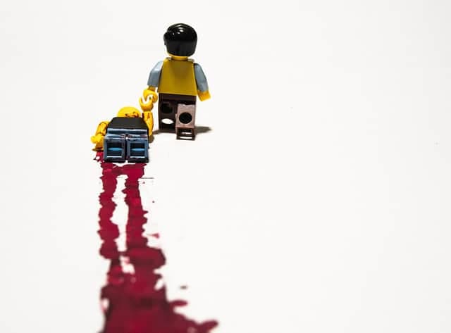 A LEGO minifig drags another minifig with a blood trail behind it.