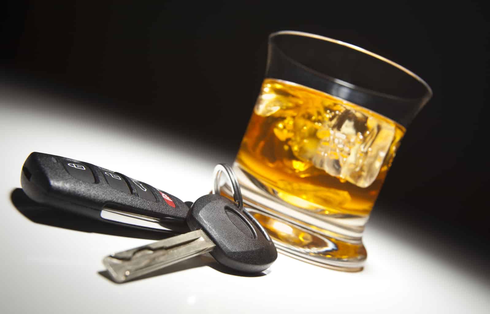 a glass of whiskey with car keys