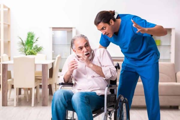 A man threatens an elderly male in a wheelchair