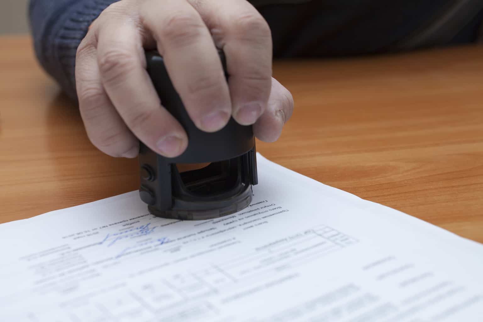 Mano estampando un documento
