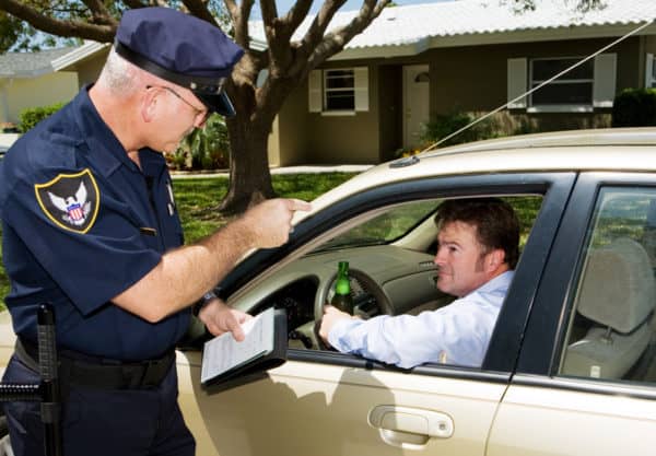 a man holding a beer pulled over by a police officer for suspicion of DUI