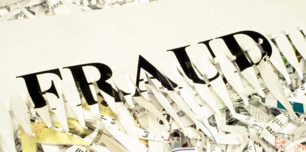 Un trozo de papel triturado con la palabra inglesa "fraude."
