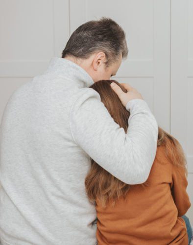 Hombre consolando a su hija
