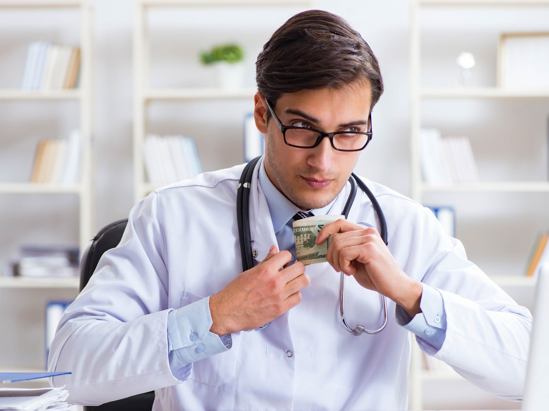 Un doctor poniendo dinero en su abrigo