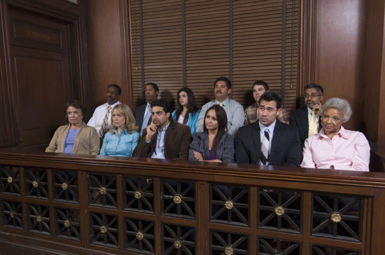 A full 12 person jury box listens to a case in a courtroom